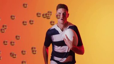 Erkek sporcu topu tutuyor ve kalp-göz dalgalarıyla tepki veriyor. Turuncu arka planda süpürüyor. Spor, atlet, coşku, enerji, coşku, ifade, hareket