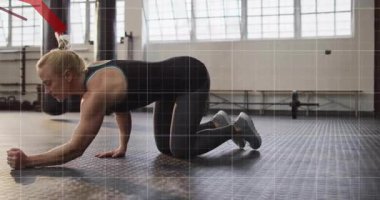 Fitness antrenörü öne uzanıyor, kırmızı iz sürme formunu kaplarken ön kol tahtasına kayıyor. Egzersiz, dayanıklılık, güç, dinamik, modern, motivasyon, sağlık