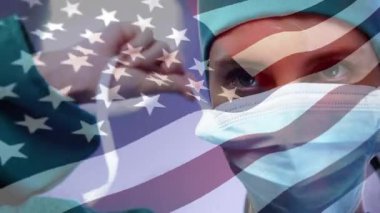 Kadın cerrah, hasta bakımı için steril eldiven giyip ABD bayrağı sallıyor. Tıbbi, sağlık, profesyonellik, kesinlik, güvenlik, vatanseverlik, modern