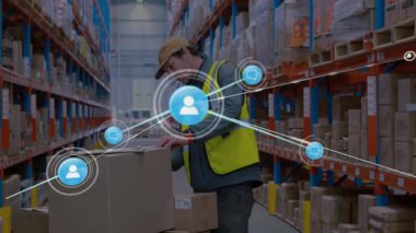 Depo işçisi, etiketi incelerken koridorda kutu kaldırıyor ve hisse senedi için ağ grafiği geliştiriyor. Lojistik, tedarik zinciri, bağlantı, otomasyon, sanayi, verimlilik, envanter
