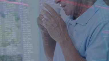 Üst düzey erkek, pencerenin yanında duruyor. Kod, veri akışını gösterirken bardaktan yudumluyor. Emeklilik, sükunet, farkındalık, dijital, boş zaman, dinginlik, rahatlama