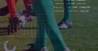 Kırmızı çoraplı oyuncu AR metriklerini çalıştırıyor yeşil oyuncu topu yana itiyor ve topu ele geçiriyor. Spor, rekabet, teknoloji, analitik, hareket, açık hava, performans