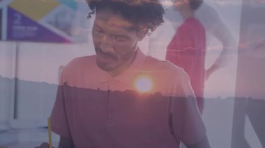 İşletme müdürü, iş arkadaşlarının notları üzerine eğilip kameraya gülümsüyor. Profesyonel, işbirliği, yenilik, modernlik, takım çalışması, beyin fırtınası, işyeri