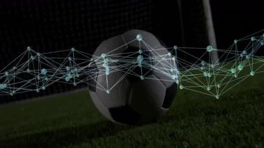 Spor teknisyenleri ışıkların altında futbol topunun üzerinden atımını üstüste koyup topa vuruyor. Stadyum, spor, dijital, bağlantı, hareket, açık hava, atletik