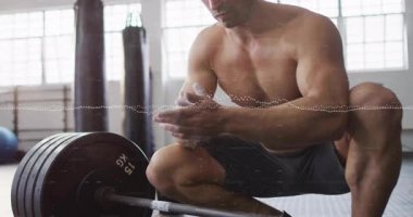 Beden eğitimi sporcusu konteynırdan tebeşir alıyor, avuç içlerini kaplıyor ve ağırlık kaldırmak için halteri çekiyor. Fitness, strength, power, determination, muscular, antrenman, egzersiz