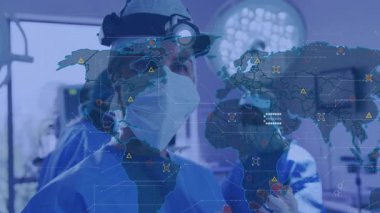 Baş cerrah, animasyon dünya haritası verilerini kullanarak konsola doğru hareket ediyor. Tıbbi, yenilik, fütüristik, işbirliği, teknoloji, sağlık, kesinlik