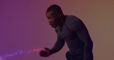 Gradyan arka planda nöbet tutan, boks yumruğu yapan ve menekşe kırmızısı enerjisi püskürten bir adam. Dövüş sanatları, çeviklik, dinamizm, modern tasarım, fitness, hareket, güç