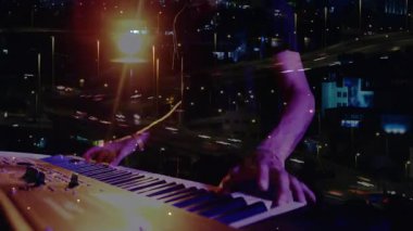 Müzisyen baskılı klavye trafik zaman ayarını başlatıyor müzik performansını şehir manzarası ile harmanlıyor. Enstrüman, ambians, neon, melodi, dijital, performans, gece manzarası