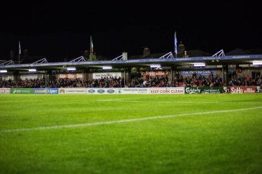 Gece futbol stadyumunda çimen sahası, bayraklar ve sponsor reklamları, projektörler var. Stadyum, meraklılar, canlı, açık hava, atmosfer, kutlama, topluluk