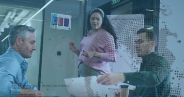 Ofisteki cam pano etrafında çalışan üç iş arkadaşından oluşan bir grup, UI modelleri ve kahve fincanı ile birlikte. İşbirliği, beyin fırtınası, yenilik, takım çalışması, modern ofis, yaratıcı