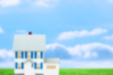 Gri çatılı, mavi panjurlu, bulutların altındaki yeşil çimenleri gösteren düz dizaynlı beyaz çift katlı bir ev. Konut, mimari, minimalist, açık hava, sükunet, cennet, doğal