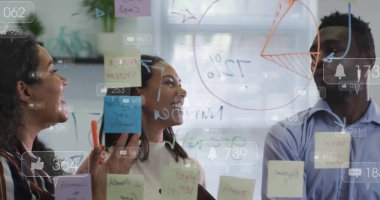 Ofisteki cam duvara pasta grafiği ve yapışkan notlarla veri çizen iş arkadaşları. Yenilik, takım çalışması, strateji, beyin fırtınası, yaratıcılık, modern, üretkenlik