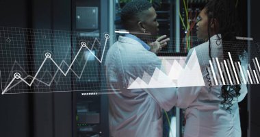 Laboratuvar önlüklü mühendisler veri merkezindeki dizüstü bilgisayarlarda rafları ve kabloları inceliyor. Teknoloji, veri, siber güvenlik, profesyonel, yenilik, dijital, ağ