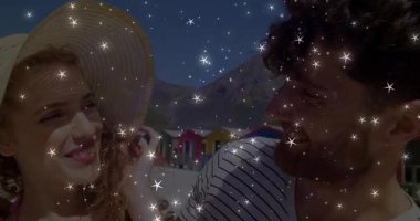 Hasır şapka kenarına dokunan bir kadın plaj yaşamını renklendiren bir yıldız örtüsüne neden oluyor. Romantizm, kıyı şeridi, yaz, eğlence, neşe, bağlantı, manzara