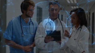 Kıdemli doktor tablet ekranına tıklıyor ve meslektaşları tıbbi veri hologramı oluşturmaya çalışıyor. Teknoloji, işbirliği, sağlık, yenilik, dijital, profesyonellik, fütüristik