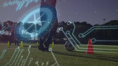 Atletin bacak ve topunun üzerinde HUD grafiği beliriyor, veri örtüleriyle koni sürme matkabını takip ediyor. Spor, eğitim, dijital, fitness, açık hava, atlet, teknoloji