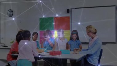 Öğretmen, altı öğrenciye kurşun kalem kutularını açmaları ve çizgi filmlerle sınıfta resim çizmeleri için rehberlik ediyor. Eğitim, yaratıcılık, işbirliği, öğrenme, sınıf, okul, çocuklar