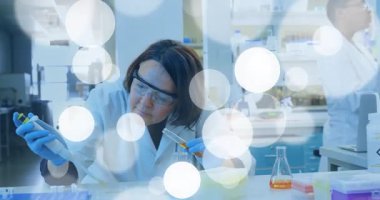 Araştırmacı, mavi solüsyon solüsyonu ve turuncu reaktörü tam laboratuvar testi için hazırlıyor. Laboratuvar, bilim, kesinlik, deney, teknoloji, modern, takım çalışması