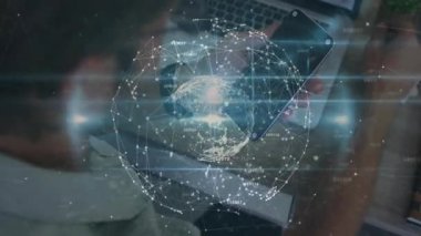 Masada akıllı telefon ve dizüstü bilgisayar kullanan bir adam dijital küre atımına ve ağ verilerini görselleştirmesine neden oluyor. Teknoloji, bağlantı, yenilik, veri, dijital, çalışma alanı, modern