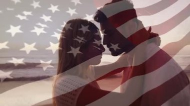 Romantik çiftin birbirine dokunan alnını gösteren bir seyahat reklamı. Sahilde dalgalanan Amerikan bayrağı gibi. Romantizm, samimiyet, sahil, günbatımı, dinginlik, aşk, doğa