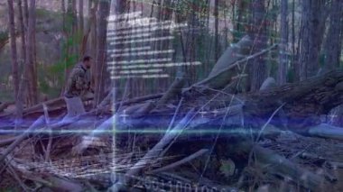 Orman adamına kamuflajlı kapüşonlu bir şekilde girmek. Teknoloji çizelgeleri yoğunlaştırırken kütükleri aşmak. Macera, keşif, vahşi doğa, navigasyon, açık hava, teknoloji, veri