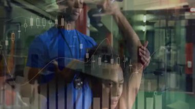 Spor hocası ellerini müşterinin bileklerine koyuyor. Uzantıya rehberlik ediyor, çizelgeleri takip ediyor. Spor, antrenman, güç, motivasyon, egzersiz, koçluk, atletizm