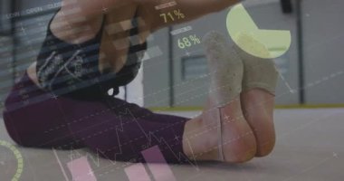 Genç jimnastikçiler spor minderinin üzerinde diz bağlarını esnetiyor ve animasyon çizelgeleriyle spor salonu verilerini takip ediyor. Fitness, esneklik, eğitim, sağlık, spor, egzersiz, sağlık