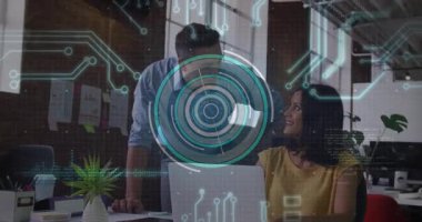 Kadın dizüstü bilgisayarda çalışırken erkek arkasından iş birliği yapıp analitik tomografi çekiyor. İşbirliği, yenilik, teknoloji, veri, dijital, takım çalışması, modern