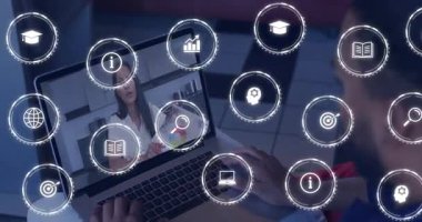 Öğrenci dokunmatik sayfaya tıklıyor. Çağrı öğretmeni, öğrenme arayüzünü çevreleyen grafik simgelerini işaret ediyor. E-öğrenme, dijital eğitim, uzak sınıf, çevrimiçi eğitim, sanal arayüz, eğitim teknolojisi, etkileşimli araçlar