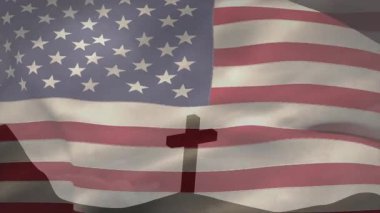 Rüzgar ABD bayrağını dalgalandırıyor, yıldız çizgileri sallanıyor alçak tepenin üstünde çapraz silueti ortaya çıkarıyor. Vatanseverlik, maneviyat, sembolik, açık hava, dinginlik, miras, tefekkür