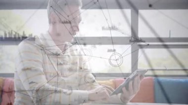 İşadamı tableti kaldırarak kanepeye dokunuyor ve parmak ile düğümler ve veri tabloları oluşturuyor. Teknoloji, yenilik, veri, analitik, fütüristik, dijital, bağlantı