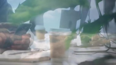 Teknoloji kullanan ve deniz manzarası ile çalışma alanını birleştiren akıllı telefon ekranını dinleyen orta yaşlı bir adam. Teknoloji, çalışma alanı, modern, gevşeme, yenilik, huzur, üretkenlik