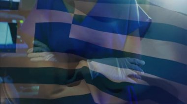 Yunan bayrağı kaplandıktan sonra sağlık uzmanı kollarını kavuşturup maskesini düzeltiyor. Tıbbi, sağlık, profesyonel, klinik, hastane, cerrahi, güvenlik