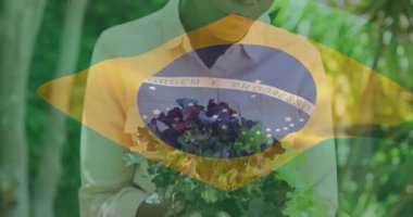 Kamera kabartmalı yeşilliklere odaklanırken, kadın nazikçe yaprakları kaldırıyor ve beslenme için inceliyor. Bahçıvanlık, sağlık, tazelik, sürdürülebilirlik, doğa, organik, sağlık