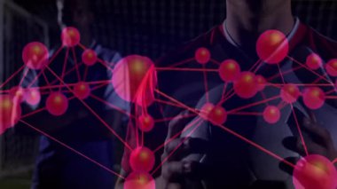 Futbolcu gece sporlarında top tutarken analitik ağ grafiğini genişletiyor. Sporcular, takım çalışması, dijital, yenilik, stadyum, rekabet, bağlantı