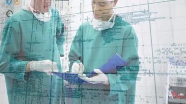 İki cerrah mavi klasörü açıyor ve ameliyat odasındaki kontrol panelini etkinleştirirken notları gözden geçiriyor. Tıbbi, takım çalışması, işbirliği, klinik, hassas, profesyonel, modern