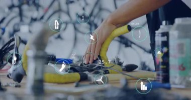 Algılayıcıları birbirine bağlayan teknisyenler ve sarı gidonun üzerindeki enerji ölçümlerini gösteren teknik simgeler. Elektronik, bakım, yenilik, ergonomik, mühendislik, atölye, veri