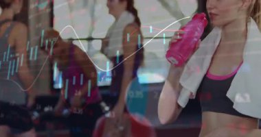 Kamera kayan bayan sporcu spor salonunda finans çizelgeleri canlandırırken şişeyi kaldırıyor ve su kaybediyor. Kardiyo, fitness, egzersiz, sağlık, aktif, motivasyon, güç
