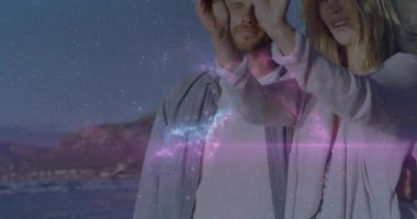 Akıllı telefonu dinleyen bir kadın, partneriyle seyahat özçekimini çeken kozmik örtüşme kayboluyor, ikisi de gülümsüyor. Romantizm, macera, manzara, şefkat, keşif, bağlantı, huzur