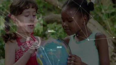 Kırmızı elbiseli kız işaret ederek dünyayı döndürüyor, arkadaşı eğitim çizgileriyle kıtaları keşfediyor. Çocuklar, eğitim, keşif, açık hava, arkadaşlık, öğrenme, keşif