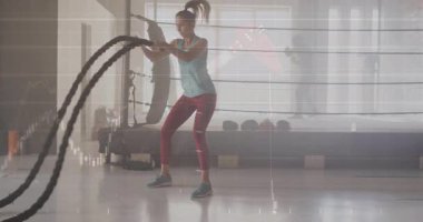 Sporcu ringe girer, savaş halatlarını yakalar ve animasyon veri grafikleriyle uyum sağlamak için dalgalar oluşturur. Güç, dayanıklılık, fitness, spor salonu, antrenman, güç, egzersiz