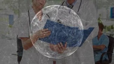 Kadın doktor muayenehaneye giriyor ve kayıtları inceleyen erkek doktora mavi klasörü veriyor. İşbirliği, profesyonellik, sağlık, danışma, sağlık ekibi, klinik çevre, belgeleme