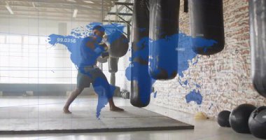 Spor salonuna giren bir adam sağlık çantasıyla boks yapıyor, mavi dünya haritası takip verilerini örtüyor. Boks, atletizm, fitness, kuvvet, antrenman, spor salonu, kararlılık