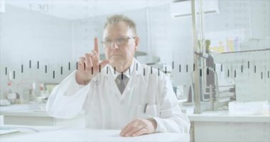 Kıdemli erkek araştırmacı, laboratuvar verilerini analiz etmek için parmağını çizgi grafiğine sokuyor, tıklatıyor ve okutuyor. Yenilik, teknoloji, analitik, veri, araştırma, bilim, fütürist