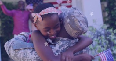 Askeri asker, eve dönüş için kızına sarılarak dönüyor. Bayrak yıldızı örtüsüyle. Aile bağları, vatanseverlik, birleşme, kutlama, açık hava, neşe, birlik