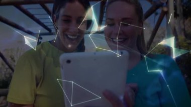 Teknoloji kullanıcıları, bahçedeki tableti eğip ağları görselleştiriyor ve üç boyutlu dünyayı döndürüyor. Fütürist, dijital, yenilik, bağlantı, işbirliği, açık hava, canlı