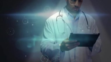 Doktor tablet ekranını tıklatıyor ve verileri analiz etmek için tıbbi halkalar ve ağ hatlarını çağırıyor. Tıbbi, teknoloji, fütüristik, arayüz, yenilik, sağlık, dijital