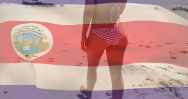 Seyahat reklamında yürüyen kadın model, kamerayla tetiklenmiş, bayrak kaplamalarıyla yüzleşmek için döndürüyor. Sahil, sahil, sandaletler, okyanus, sükunet, boş zaman, açık hava.