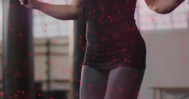 Spor salonunda atlama halatına başlayan bayan sporcu, kırmızı parçacık izleriyle fitness için ön plana çıkıyor. Spor, spor, atletizm, hareket, canlılık, güç, eğitim