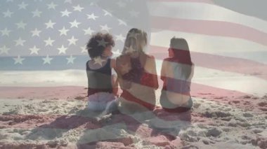 Seyahat arkadaşları, dalgalanan bayrağın üstünde başlarını sallayarak okyanus dalgalarını kaplayarak günbatımını yakalıyorlar. Kumsal, dostluk, rahatlama, güneşli, ufuk, okyanus, boş zaman